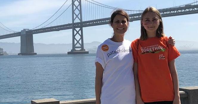 photo of two people in front of a bridge